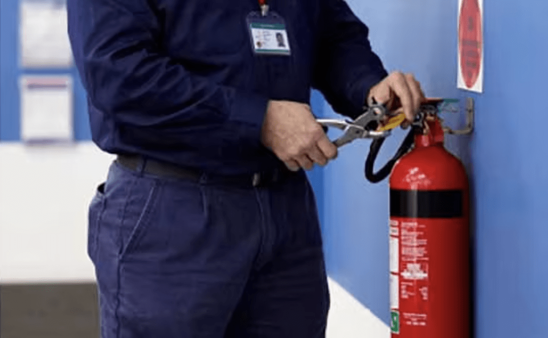 Man servicing a fire extinguisher